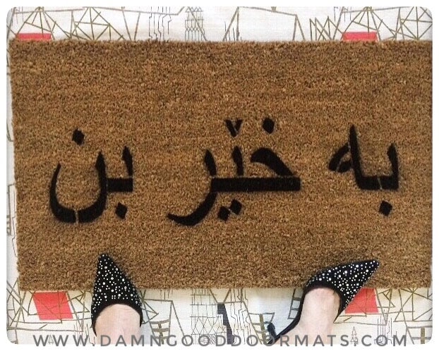 Promotional graphic for an eco-friendly coir doormat made by Damn Good Doormats reading Welcome in Arabic calligraphy